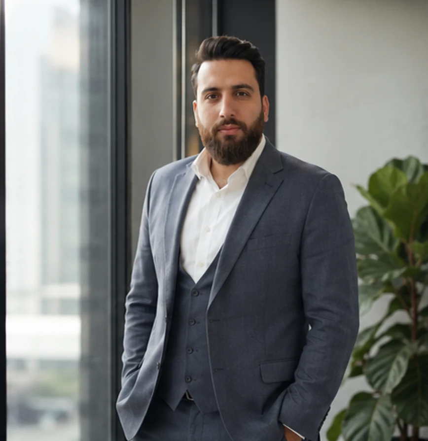 Hossein Barzegar standing beside a window in a professional portrait.